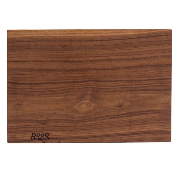 A John Boos black walnut wood cutting board with the word "pears" carved on it.