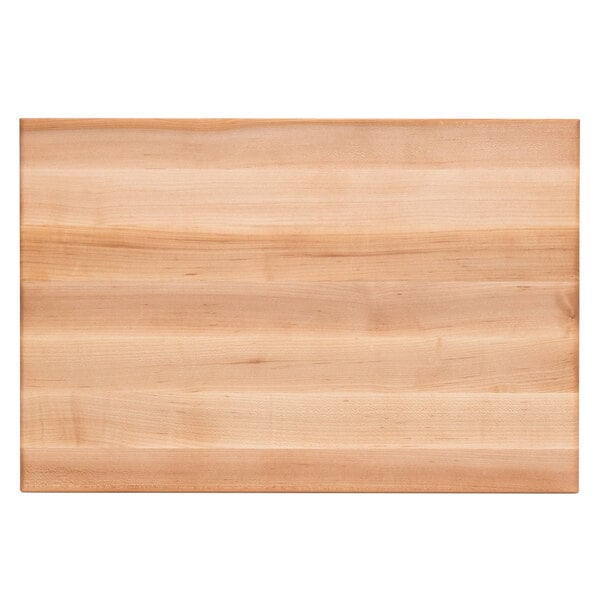 A John Boos maple wood cutting board with hand grips on a table.