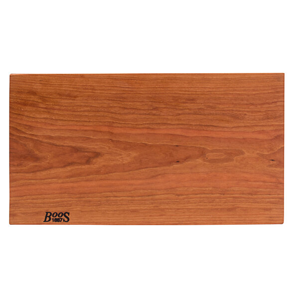 A John Boos cherry wood cutting board with a rustic edge and logo on it.