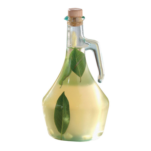 A Tablecraft glass olive oil bottle with liquid and leaves.