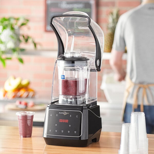 A AvaMix commercial blender filled with red liquid on a counter.