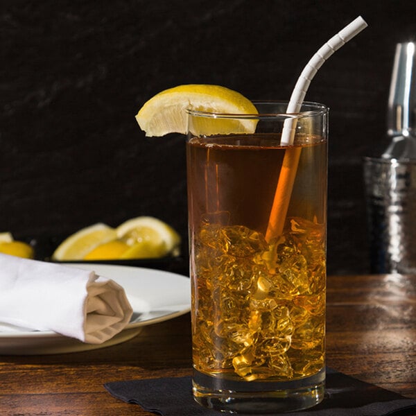 A glass of iced tea with a Aardvark paper straw and a lemon wedge.