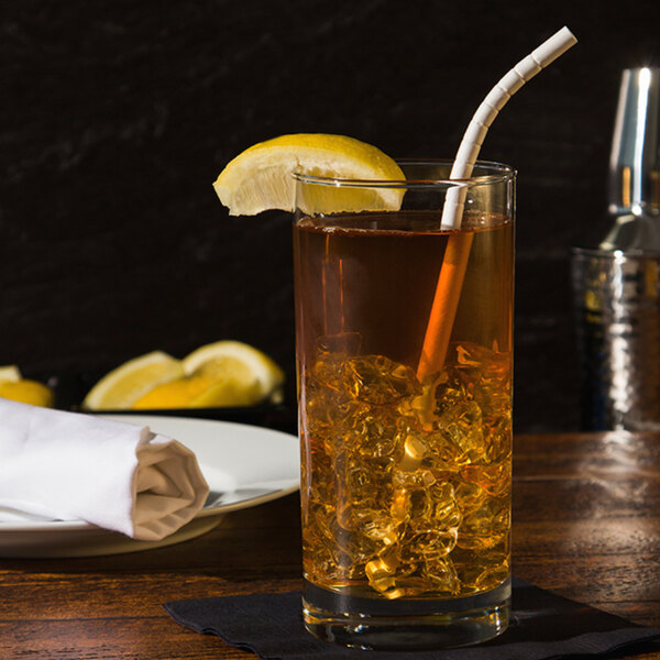 A glass of iced tea with a Aardvark paper straw and lemon slice.