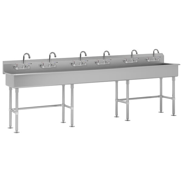 A long stainless steel multi-station hand sink with faucets.