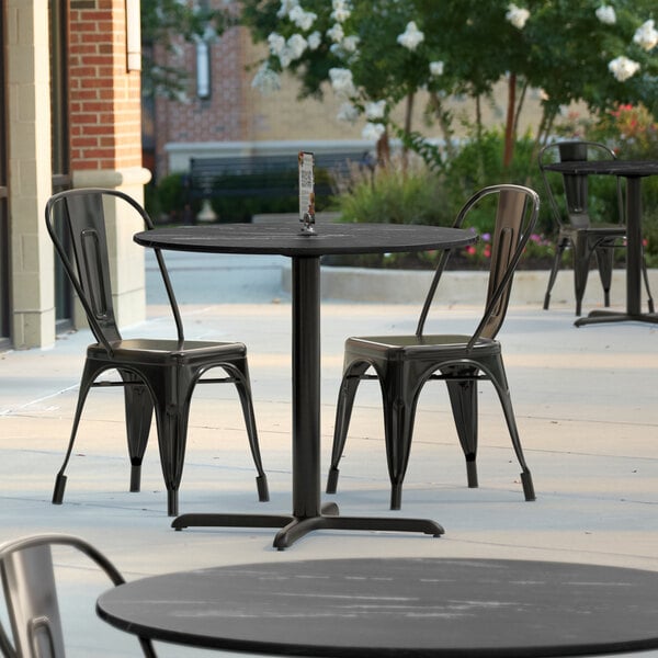 A Lancaster Table and chairs on a patio with a cross base plate.