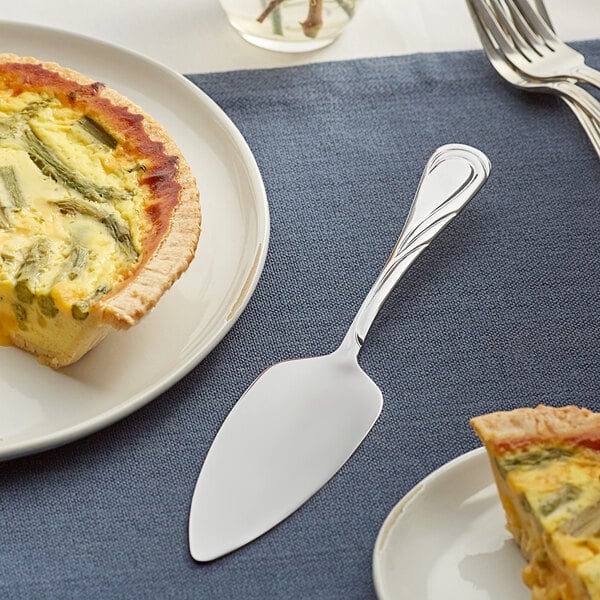 An Acopa stainless steel pastry server with a slice of quiche on a plate.