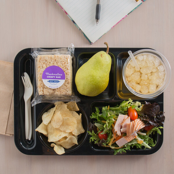 A Carlisle black 6 compartment tray with a salad, chips, and a pear on it.