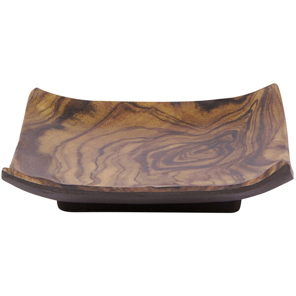 A wooden plate with a brown wood grain design on a table.