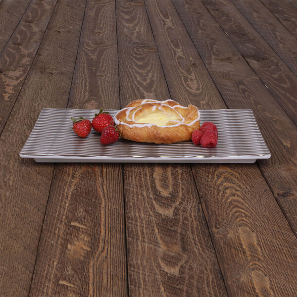 A pastry and strawberries on an Elite Global Solutions brown textured melamine platter.