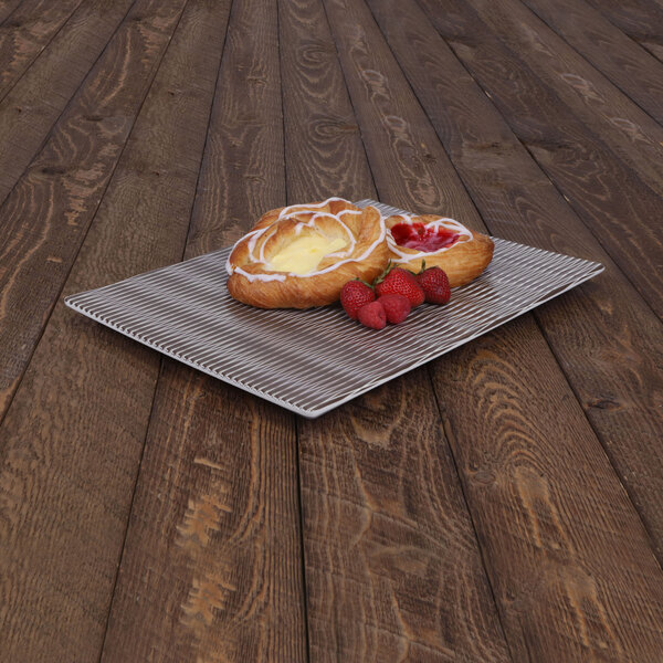 An Elite Global Solutions brown textured melamine platter with pastries and berries on it.