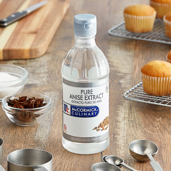 A bottle of McCormick Pure Anise Extract next to a variety of cupcakes.