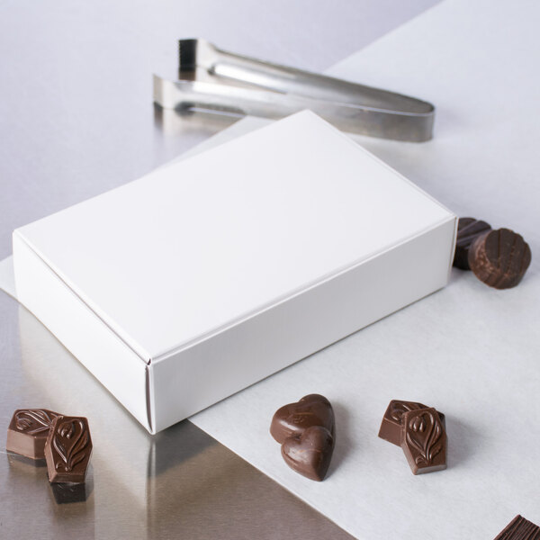 A white box for 1 1/2 lb. of candy with chocolates on it.