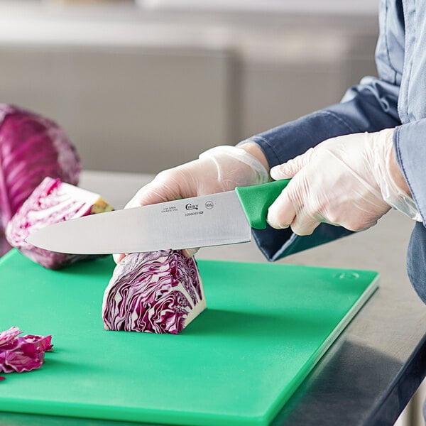 A person cutting cabbage on a cutting board with a Choice 8" chef knife.