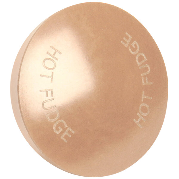 A copper round knob with the words "Hot Fudge" on it.