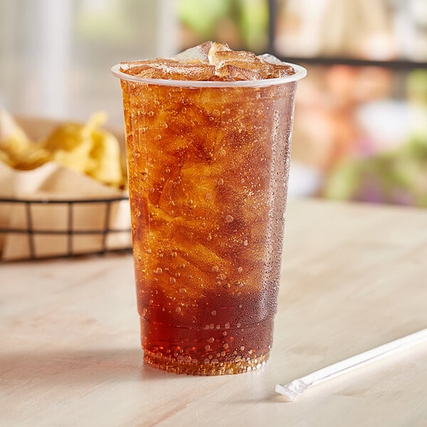 A glass of brown liquid with ice and a straw in an EcoChoice PLA compostable plastic cup.