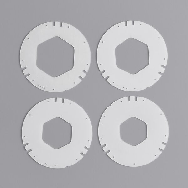 A group of four white circular plastic pieces.
