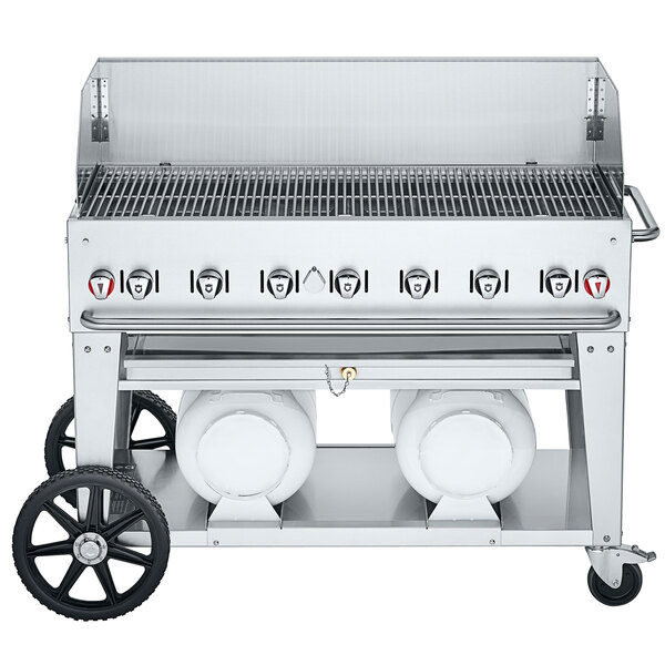 A Crown Verity Club Series outdoor grill on wheels with a wind guard and two horizontal propane tanks.