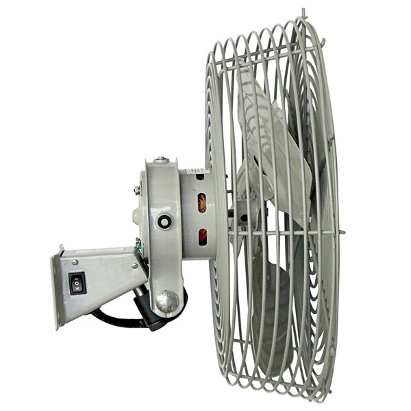 A white TPI industrial wall-mount fan with a metal cage.