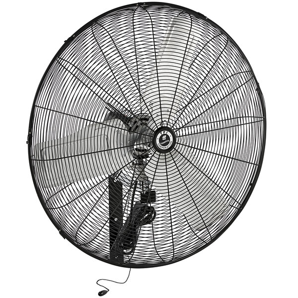 A large black TPI wall-mount fan with a metal structure.