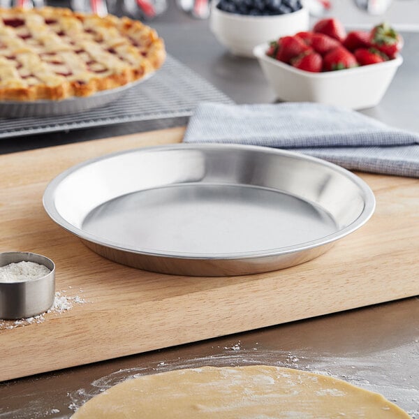 A close-up of a Baker's Mark aluminum pie pan filled with a pie on a cutting board.