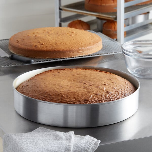 A cake in a Choice round aluminum cake pan on a counter.
