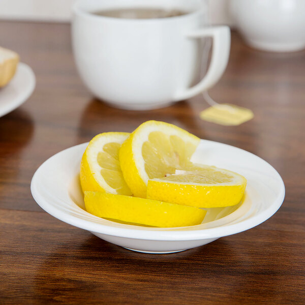 A white porcelain bowl filled with lemon slices.