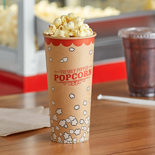A close up of a brown Carnival King Kraft popcorn cup on a table with popcorn inside.