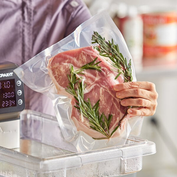 A woman holding a Choice vacuum packaging bag filled with meat.