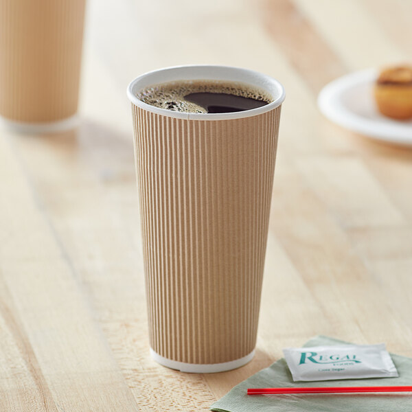 A close-up of a brown Choice double wall paper hot cup on a table.