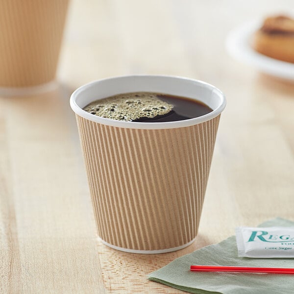 A Choice double wall kraft paper hot cup with a drink in it.