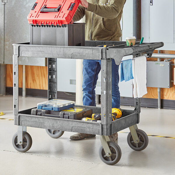 A man standing next to a Lavex utility cart with tools on it.