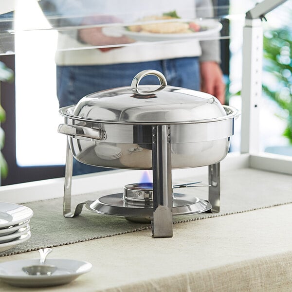 A Choice stainless steel chafer with chrome accents on a table outdoors.