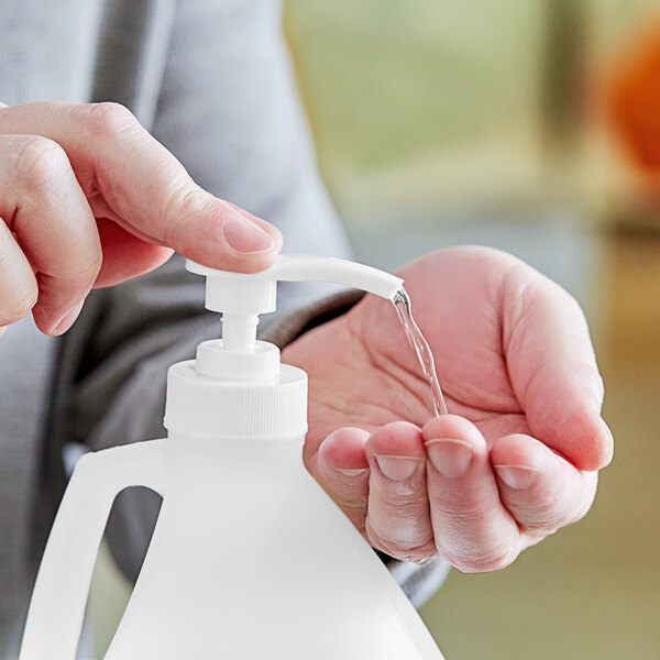 A person using a pump dispenser to apply hand sanitizer.