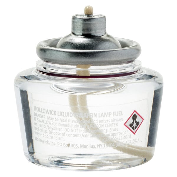 A clear glass Hollowick liquid fuel cartridge with a metal cap.