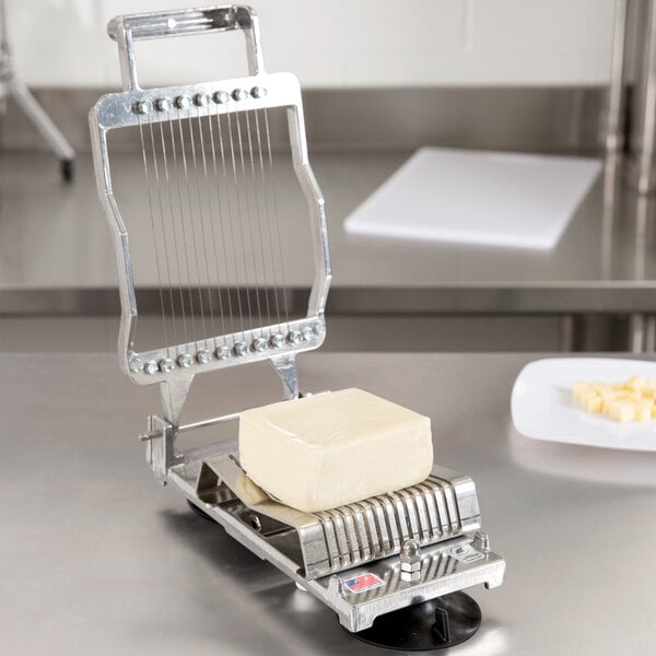 A Nemco Mozzarella Cheese Slicer with a 5/16" slicing arm on a block of cheese.