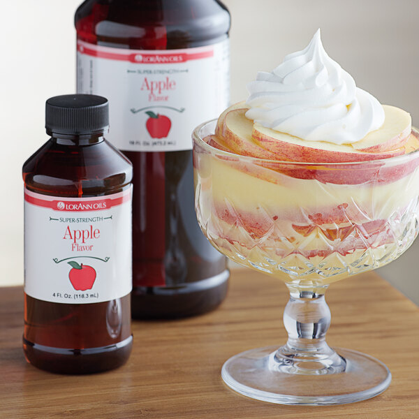 A dessert in a glass with white whipped cream and LorAnn Oils Apple Super Strength Flavor syrup.