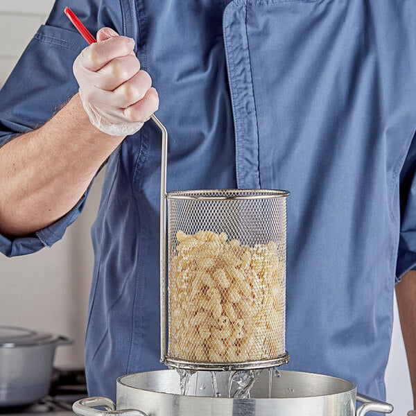 A person using a Choice stainless steel strainer to stir pasta in a pot.