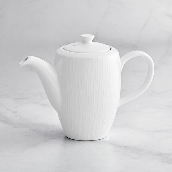 A RAK Porcelain white porcelain coffee pot with a lid on a marble surface.
