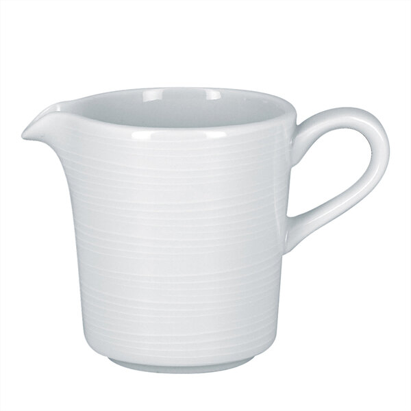 A RAK Porcelain bright white porcelain creamer with an embossed design and a handle.