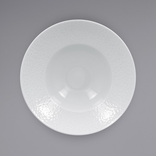 A close up of a RAK Porcelain Charm white porcelain plate with an embossed rim.