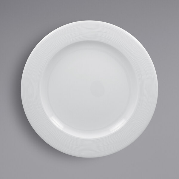 A white RAK Porcelain plate with a circular embossed design around the rim.