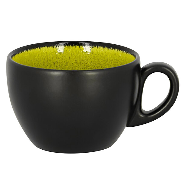 A green RAK Porcelain coffee cup with a black interior and yellow rim.