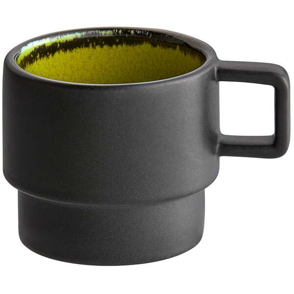A green porcelain espresso cup with a yellow rim.