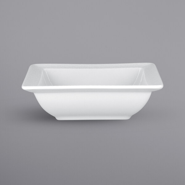 A bright white square porcelain bowl with an embossed pattern.