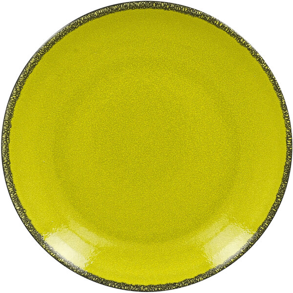 A green porcelain coupe plate with black speckled edges.