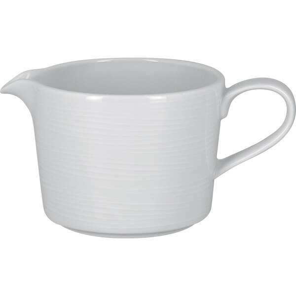 A white gravy boat with a handle.