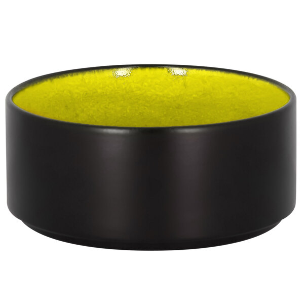 A green RAK Porcelain stackable bowl with a yellow rim.