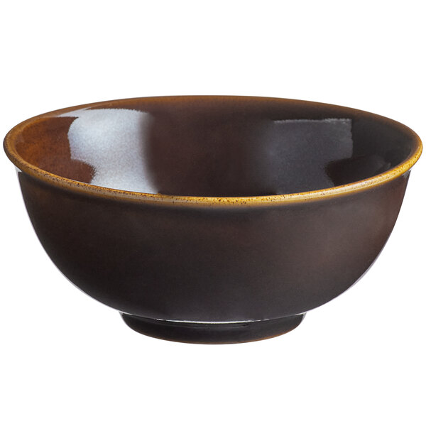 A white porcelain bowl with a brown exterior and yellow rim.