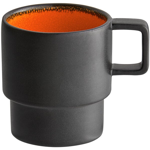 A black coffee cup with an orange rim.