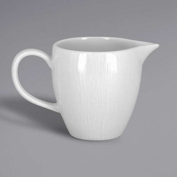 A RAK Porcelain bright white embossed porcelain creamer with a handle.